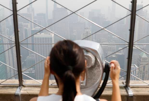 Tourists visit the observation deck of the Empire State Building as haze and smoke due to on going wildfires in Canada shroud the views of the Manhattan skyline on Friday, June 30, 2023 in New York City.  NYP20230630112 JohnxAngelillo