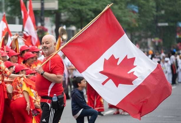 News Bilder des Tages July 1, 2023, Montreal, PQ, Canada: A man carries a Canadian flag prior to the Canada Day parade in Montreal, Saturday, July 1, 2023. Montreal Canada  - ZUMAc35_ 20230701_zaf_c35_001 Copyright: xGrahamxHughesx