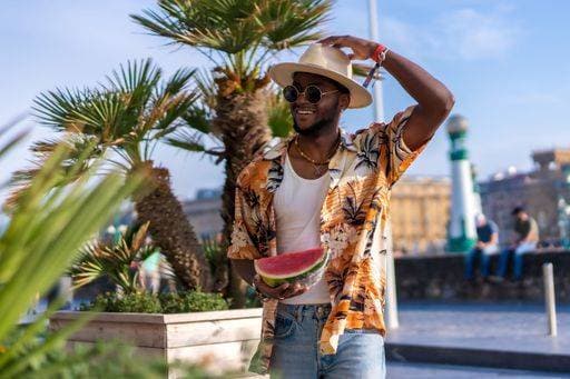 A shallow focus of a young handsome black man eating fresh watermelon at the beach *** einer seicht Fokus des einer Jung gutaussehenden Schwarz Mann essender Frisch Wassermelone im der Strand 19751190 ,model released, Symbolfoto RECORD DATE NOT STATED