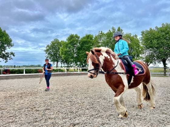 IMAGO Creative, Kinder auf dem Reiterhof Mädchen auf einem Pferd, Pony, Reitunterricht, Reiten, Reitsport, Pferdereiten, Reitstunde, Reitlehrer, Reitpädagogik, Reitverein, Reithalle, Reitplatz, Reitwege, Reitausrüstung, Pferdepflege, Pferdehaltung, Pferdegesundheit, Pferdeausbildung, Pferdesprung, Reitschule, Reitferien, Reitwettbewerb, Reiterin, Pferdefreunde, Pferdeliebhaber, Pferdebegeisterte (Hinweis: Model Release und Zustimmung zur redaktionellen Veröffentlichung des Kind auf dem Pferd liegt vor) Symbolbild - 05.07.2023; Westeraccum, Dornum, Ostfriesland, Nordsee, Niedersachsen, Deutschland, Europa *** Girl on a horse, pony, riding lessons, riding, equestrian sports, horse riding, riding lesson, riding instructor, riding pedagogy, riding club, riding hall, riding arena,