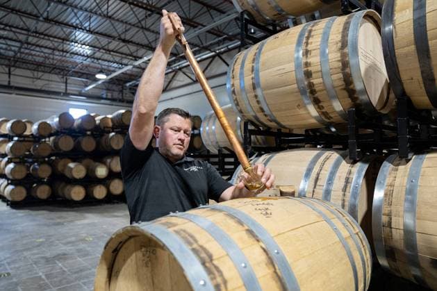 May 31, 2023, River Falls, WI, USA: Jon Kreidler, co-founder of Tattersall Distillery, pulls a small amount of Kernza Whiskey from a barrel as it ages Wednesday, May 31, 2023, at Tattersall Distillery in River Falls, Wisconsin. River Falls USA - ZUMAm67_ 20230531_zaf_m67_035 Copyright: xAlexxKormannx
