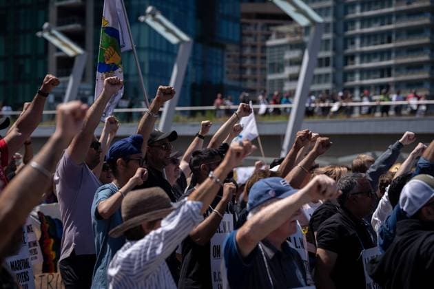 July 9, 2023, VANCOUVER, BC, CANADA: Striking port workers from the International Longshore and Warehouse Union Canada hold up their fists while attending a rally in Vancouver, on Sunday, July 9, 2023. VANCOUVER CANADA  - ZUMAc35_ 20230709_zaf_c35_044 Copyright: xEthanxCairnsx