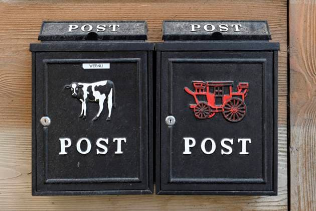 Briefkasten mit Milchkuh und Kutsche Symbolbild, Schweiz, 04.07.2023 *** Mailbox with milk cow and carriage icon image, Switzerland, 04 07 2023 