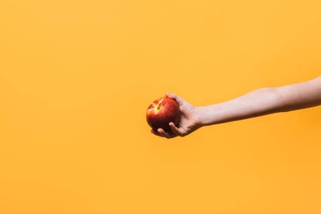 Crop person with apple over yellow background Crop anonymous child with hand holding freshly ripe red apple against yellow studio background HodeiUnzueta_ID15006_458361_004 Copyright: xHodeixUnzuetax RECORD DATE NOT STATED Model Released