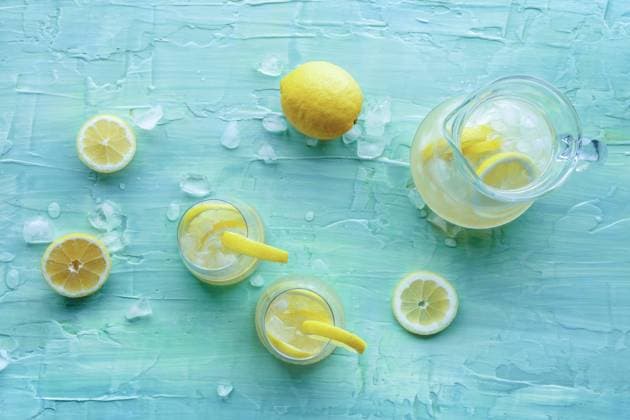 Lemonade. Lemon water drink with ice. Two glasses and a pitcher on blue Lemonade. Lemon water drink with ice. Two glasses and a pitcher on a blue background, overhead flat lay shot. Detox beverage. Fresh homemade cocktail Copyright: xZoonar.com KaterinaxSolovyevax 20333751