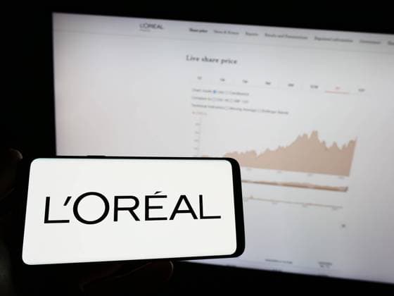 Person holding mobile phone with logo of French personal care company L Oreal S.A. on screen. Stuttgart, Germany - 04-04-2023: Person holding mobile phone with logo of French personal care company L Oreal S.A. on screen in front of web page. Focus on phone display. Copyright: xZoonar.com TimonxSchneiderx 20159432