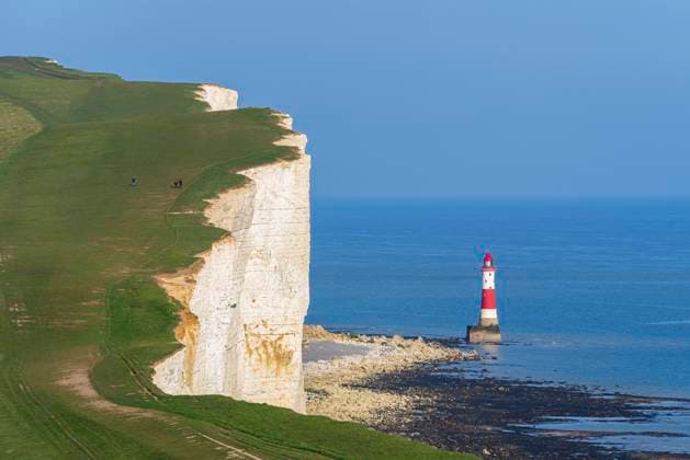 View of the coast of the Seven Sisters white chalk cliffs with the Beachy Head lighthouse in the background, South Downs National Park, East Sussex, England, United Kingdom, Europe Copyright: PaoloxGraziosi 1361-156