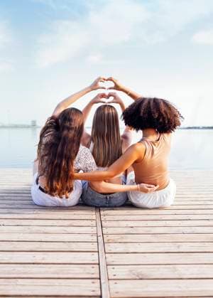 Three female teenagers of different ethnic groups show heart symbols with their hands Three female teenagers of different ethnic groups show heart symbols with their hands. Teen girls in casual clothes sit on wooden bridge near the river or lake and hug. Friendship concept. Copy space ,model released, Symbolfoto Copyright: xZoonar.com DashaxPetrenkox 20393557 ,model released, Symbolfoto ,property released