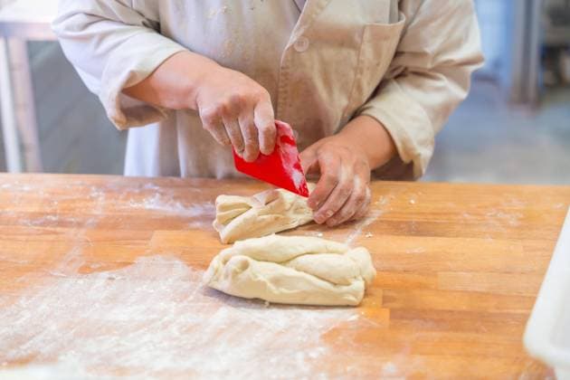  Angestellte eines Brotbackautomaten in der Werkstatt einer handwerklichen Bäckerei beim Schneiden von Teig *** Employees one Bread machines in the Workshop a handicraft Bakery at Cutting from Dough Copyright: imageBROKER/UnaixHuizi ibxuhu09402063.jpg ,model released, Symbolfoto ,property released