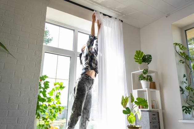 IMAGO Creative: Frühjahrsputz Woman hangs transparent tulle curtains on large windows in the house inside the interior. Spring cleaning, tidying up. Woman hangs transparent tulle curtains on large windows in the house inside the interior. Spring cleaning, tidying up. ,model released, Symbolfoto Copyright: xZoonar.com OlgaxSimonovax 20459171 ,model released, Symbolfoto ,property released
