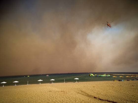 (230723) -- RHODES ISLAND, July 23, 2023 -- A helicopter is seen above the Rhodes island in Greece, July 22, 2023. At least 2,000 residents and holidaymakers were evacuated by sea in the fire-stricken areas of Rhodes island in Greece on Saturday evening, authorities said. (Photo by Xinhua) GREECE-RHODES ISLAND-WILDFIRE ArgirisxMantikos 