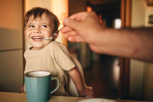 Creative Highlights Symbolbilder Father feeding breakfast to laughing son at home model released, Symbolfoto property released, ANAF01775