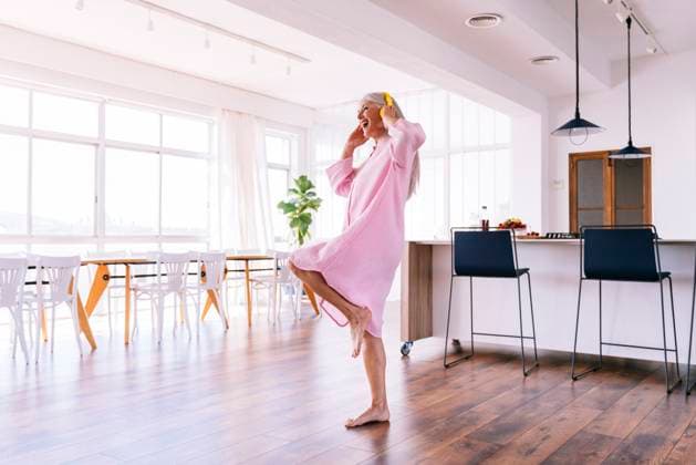 Cheerful woman with yellow headphones dancing at home model released, Symbolfoto property released, OIPF03349