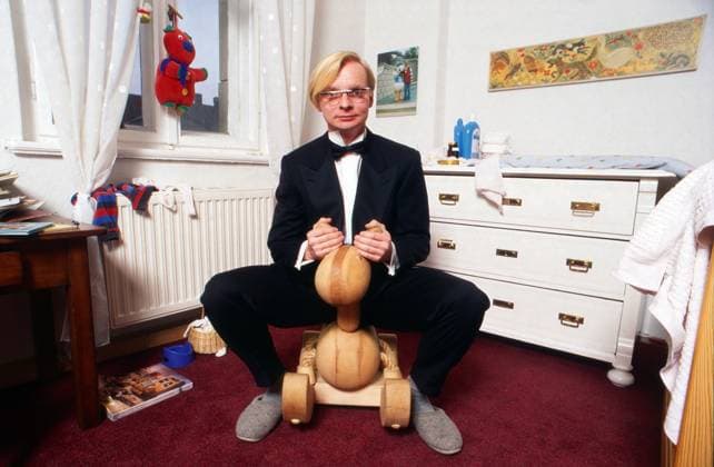 Uwe Steimle, deutscher Kabarettist und Schauspieler, im Smokinganzug auf einem Holzreitpferd im Kinderzimmer bei einer Homestory in Dresden, Deutschland 1996. Dresden Sachsen Deutschland Copyright: xUnitedxArchivesx xAlexanderxStingl STI_8700000103 EDITORIAL USE ONLY