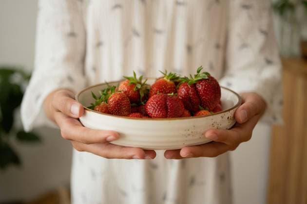 PR_ID15648_4255_Room.jpg, MR_ID15648_14434_MayaSolopova.jpg Crop anonymous woman in white gown showing white bowl with fresh strawberries while standing on blurred background in daylight, Property released MR LiliyaSolopova_ID15648_475509_006 Copyright: xLiliyaxSolopovax Model Released