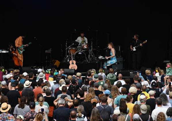 Musikfestival Heimspiel Knyphausen (28. bis 30. Juli 2023), Konzert der Band >> Paula Paula << am Sonntag, 30. Juli 2023. Auftritt der Musikband >> Paula Paula << beim Festival >> Heimspiel Knyphausen << am 30. Juli 2023. Zu sehen die Bühne der Musiker um Bandleaderin und Songschreiberin Marlène Colle (Mitte) und Gisbert zu Knyphausen (bass) (re.) sowie das Publikum, die Zuhörer vor der Bühne. Eltville-Erbach Eltville am Rhein Rheinland-Pfalz Deutschland Weingut Baron von Knyphausen
