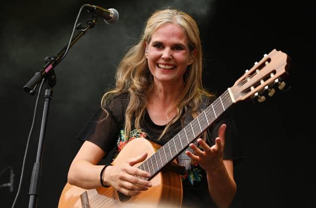 Musikfestival Heimspiel Knyphausen (28. bis 30. Juli 2023), Konzert der Band >> Dota << am Sonntag, 30. Juli 2023. Auftritt der Band >> Dota << beim Festival >> Heimspiel Knyphausen << am 30. Juli 2023. Zu sehen Bandleaderin Dota Kehr (Gesang, Gitarre) in Aktion am Mikrofon und der Akustik-Gitarre. Eltville-Erbach Eltville am Rhein Rheinland-Pfalz Deutschland Weingut Baron von Knyphausen