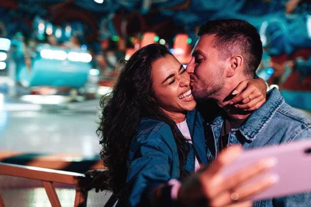 Creative Highlights Symbolbilder Boyfriend kissing his girlfriend while she is making selfie. Young couple during a summer festival. Boyfriend kissing his girlfriend while she is making selfie. Young couple during a summer festival. Copyright: xxArtemxVarnitsinx
