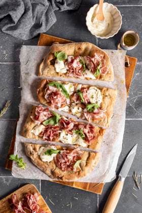 Slices pinsa with prosciutto, cheese, arugula Slices pinsa with prosciutto, cheese, arugula Copyright: xSoniaxBozzox SBO310723-31