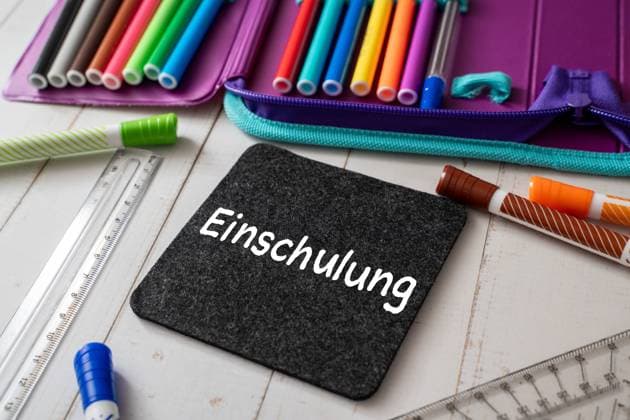 8 August 2023: Board with inscription: Enrollment. First day of school for children in school. School pencil case with colorful pens PHOTOMONTAGE *** Tafel mit Aufschrift: Einschulung. Erster Schultag für Kinder in der Schule. Schulmäppchen mit bunten Stiften FOTOMONTAGE