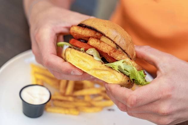 21 July 2023: Person is in a restaurant a vegetarian hamburger with halloumi cheese. Halloumi burger *** Person ist in einem Restaurant einen vegetarischen Hamburger mit Halloumi Käse. Halloumi Burger