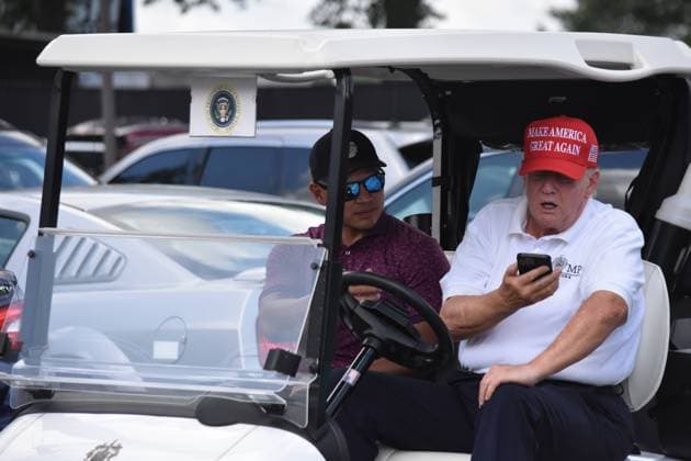 August 13, 2023, Bedminster, New Jersey, United States: Former President of the United States Donald J. Trump in the golf cart talking with someone on the phone. Former President of the United States Donald J. Trump (Right) and Walt Nauta (Left) drive by the media center at LIV Golf Bedminster 2023 at Trump National Golf Club Bedminster. Bedminster United States - ZUMAs197 20230813_aaa_s197_002 Copyright: xKylexMazzax