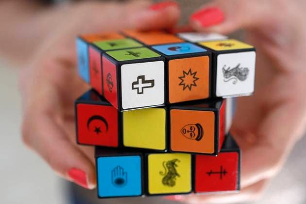 Woman with a Rubik s cube with religious symbols Woman with a Rubik s cube with religious symbols. Interreligious and interfaith dialog concept. Copyright: xGODONGx xBSIPx 016082_266 Bsip_016082_266