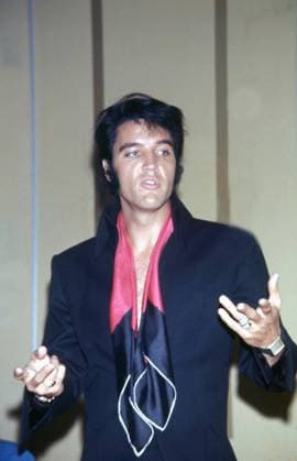 Elvis Presley in close-up, wearing a black jacket and scarf, gesturing, circa 1970s. Photo: Oscar Abolafia Everett Collection (elvispresley002)OSAB001 J4728 PUBLICATIONXNOTxINxCANxCHNxFRAxITAxJPNxNORxPOLxRUSxESPxUKxUSA Copyright: xx OSAB001 J4728 OSAB001_J4728_H