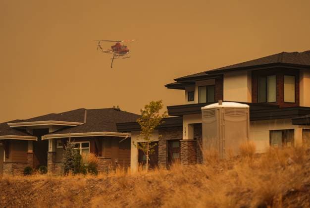 August 18, 2023, KELOWNA, BC, CANADA: A helicopter equipped to respond to wildfires flies past homes in the Wilden neighbourhood near Knox Mountain after RCMP officers enforced a new evacuation order, in Kelowna, B.C., Friday, Aug. 18, 2023. KELOWNA CANADA  - ZUMAc35_ 20230818_zaf_c35_064 Copyright: xDarrylxDyckx