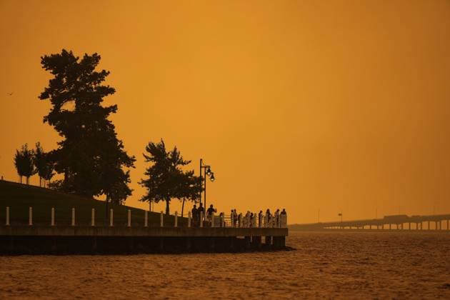 August 18, 2023, KELOWNA, BC, CANADA: Smoke from the McDougall Creek wildfire fills the air and nearly blocks out the sun as people take in the view of Okanagan Lake from the downtown boardwalk, in Kelowna, B.C., Friday, Aug. 18, 2023. KELOWNA CANADA  - ZUMAc35_ 20230818_zaf_c35_054 Copyright: xDarrylxDyckx
