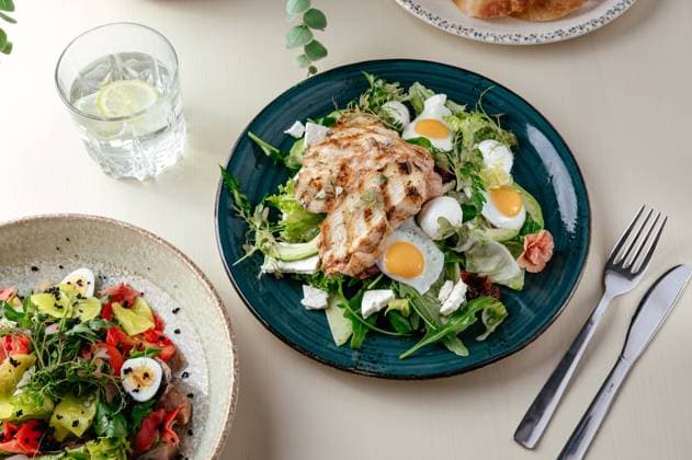 warm salad with grilled chicken and egg . restaurant menu R_KUAL230815-1233869-01
