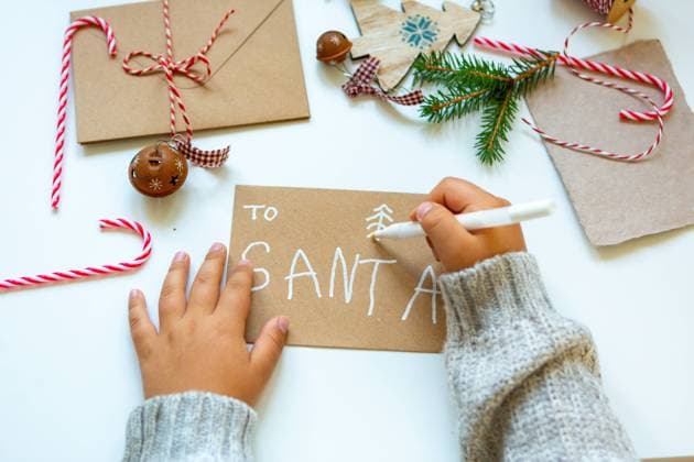 11 August 2023: A child writes a letter to Santa Claus, hands of a young write a letter with a wish list for Christmas. Text: to Santa *** Ein Kind schreibt einem Brief an den Weihnachtsmann, Hände von einem jungen schreiben einen Brief mit einer Wunschliste für Weihnachten. Text: to Santa