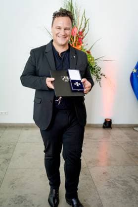 Verleihung des Verdienstorden des Landes Nordrhein-Westfalen Guido Maria Kretschmer aus Hamburg der Modedesigner und beliebte Moderator praesentiert seinen soeben ueberreichten Verdienstorden im Anschluss an die Verleihung des Verdienstorden des Landes Nordrhein-Westfalen in der Staatskanzlei in Duesseldorf, Düsseldorf, 22.08.2023 Duesseldorf Nordrhein-Westfalen Deutschland