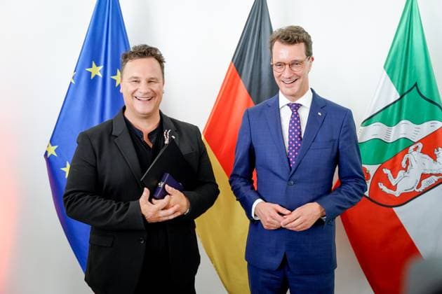 Verleihung des Verdienstorden des Landes Nordrhein-Westfalen Guido Maria Kretschmer aus Hamburg der Modedesigner und beliebte Moderator mit Hendrik Wuest Ministerpraesident von Nordrhein-Westfalen mit dem Verdienstkreuz und der Urkunde im Anschluss an die Verleihung des Verdienstorden des Landes Nordrhein-Westfalen in der Staatskanzlei in Duesseldorf, Düsseldorf, 22.08.2023 Duesseldorf Nordrhein-Westfalen Deutschland