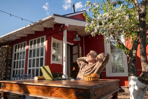 Freelancer with laptop on table relaxing outside house model released, Symbolfoto property released, VPIF08354