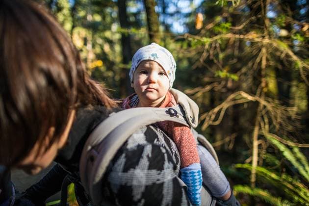 Baby gets a ride in carrier on mothers back in forest. Vancouver, British Columbia, Canada CR_JDIP230812-866464-01 ,model released, Symbolfoto
