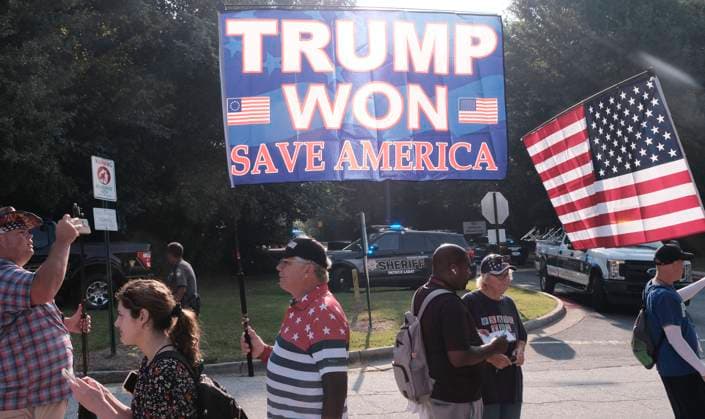 August 24, 2023, Atlanta, Georgia, USA: A supporter of former President Donald Trump holds a flag that says TRUMP WON SAVE AMERICA as a large cowd of Trump supporters rallied at the Fulton County Jail in Atlanta where the former president was to turn himself in after being indicted on charges related attempting to overturn the results of the 2020 presidential election, which he lost to Joe Biden. Atlanta USA - ZUMAb165 20230824_znp_b165_003 Copyright: xJohnxArthurxBrownx