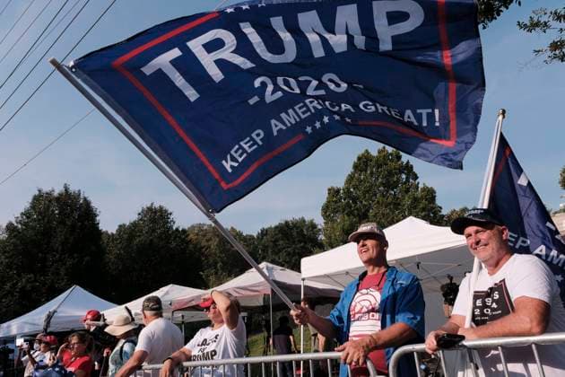 August 24, 2023, Atlanta, Georgia, USA: A supporter of former President Donald Trump holds a flag as a large crowd of Trump supporters rallied at the Fulton County Jail in Atlanta where the former president was to turn himself in after being indicted on charges related attempting to overturn the results of the 2020 presidential election, which he lost to Joe Biden. Atlanta USA - ZUMAb165 20230824_znp_b165_006 Copyright: xJohnxArthurxBrownx