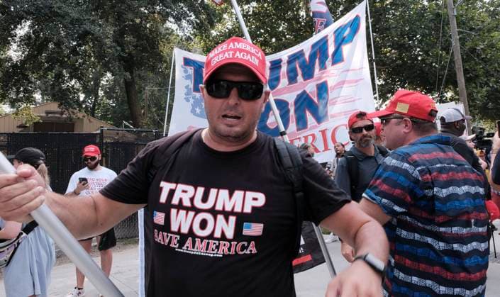 August 24, 2023, Atlanta, Georgia, USA: A supporter of former President Donald Trump wears a t-shirt that say TRUMP WON SAVE AMERICA as a large crowd of Trump supporters rallied at the Fulton County Jail in Atlanta where the former president was to turn himself in after being indicted on charges related attempting to overturn the results of the 2020 presidential election, which he lost to Joe Biden. Atlanta USA - ZUMAb165 20230824_znp_b165_024 Copyright: xJohnxArthurxBrownx
