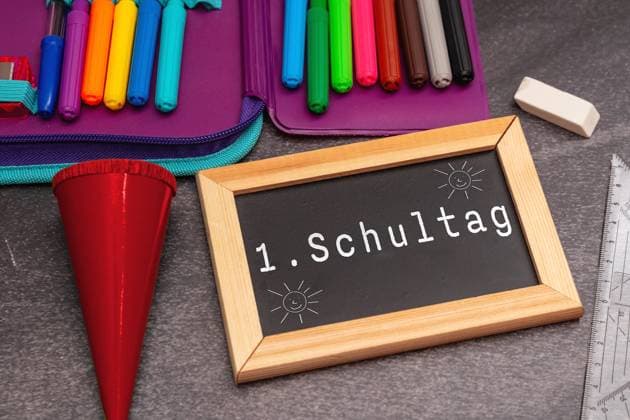 Bavaria, Germany - 24 August 2023: Chalkboard with inscription: 1st day of school. School pencil case with stationery and crayons. Enrollment in school on the first day of school PHOTO MONTAGE *** Kreidetafel mit Aufschrift: 1. Schultag. Schulmäppchen mit Schreibwaren und Buntstiften. Einschulung am ersten Schultag in die Schule FOTOMONTAGE