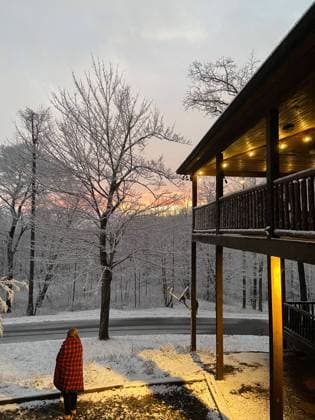 Woman in a red plaid blanket stands outside a snowy cabin United States, Georgia, Ellijay R_NHDH230808-1231608-01 ,model released, Symbolfoto