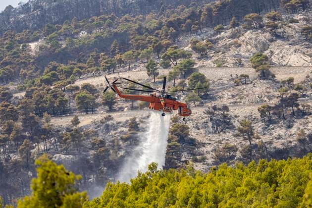 Mount Parnitha Wildfire Near Athens Mount Parnitha wildfire at the outskirts of Athens with visible smoke after the catastrophic blaze, resulting in an environmental disaster, at the forest north of Athens, a National Park with protected wildlife. An S-64E Erickson Air-Crane with tail number 741 - N176AC as seen flying and dropping water assisting the ground forces of the fire brigade to extinguish the burning forest and create fire brakes. Sikorsky S-64E Skycrane, from Erickson Air-Crane company is under contract for the Hellenic Air Force and Fire Department. The iconic chopper has the name Marty. It can release up to 9,500 liters of water in a single drop. Acharnes, Athens, Greece on August 2023 Athens Greece  Copyright: xNicolasxEconomoux originalFilename: economou-mountpar230824_npJl7.jpg
