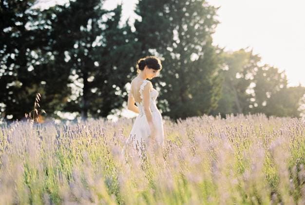 Bride in a white dress stands in a lavender field with her head down. Side view Bride in a white dress stands in a lavender field with her head down. Side view. High quality photo ,model released, Symbolfoto Copyright: xZoonar.com VolodymyrxNadtochiix 19167941 ,model released, Symbolfoto ,property released