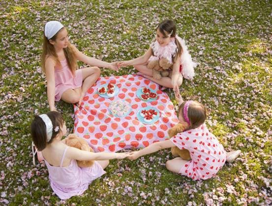 Four young girl sitting around a colorful blanket holding hands and having a party United Kingdom  Copyright: JuttaxKlee fStopImages2044017 ,model released, Symbolfoto