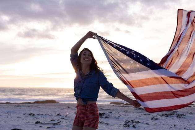 Creative Highlights Symbolbilder Woman holding waving American flag on the beach Woman holding waving American flag on the beach during sunset, model released, , property released, Cork, Ireland, 29.03.2019, 1250966.jpg, millennial, beach, sky, sunny, summer, sunset, nature, flag, american flag, identity, patriotic, patriotism, standing, holding, waving, smiling, happy, cheerful, beautiful, pretty, attractive, gorgeous, modern, travel, travel destination, tourism, holiday, vacation, weekend activity, carefree, freedom, recreation, leisure, lifestyle Outdoors,Dusk-Twilight,Half length