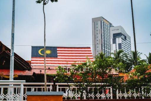 The Malaysian flag in the city of Malaka, Malaysia, with buildings in the background 21049379