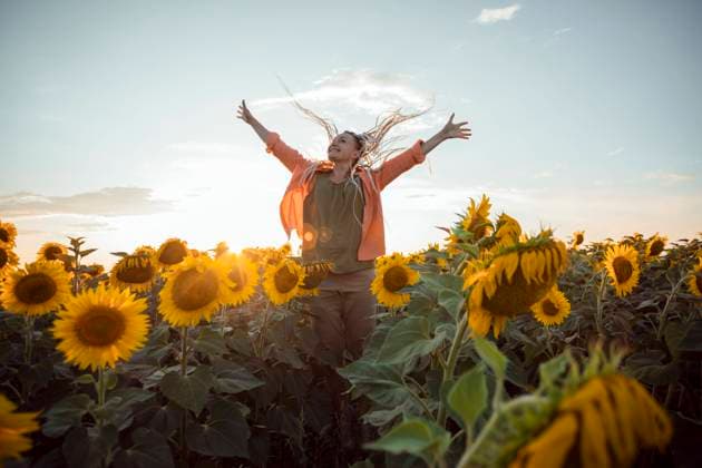 Happy woman with arms outstretched standing in sunflower field model released, Symbolfoto property released, ADF00144