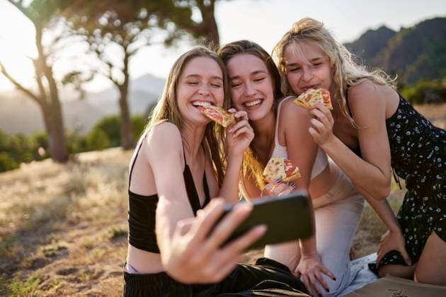 Cheerful young friends having pizza and taking selfie through smart phone model released, Symbolfoto, ANNF00361