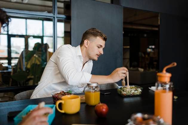 Businessman eating food from container at office model released, Symbolfoto property released, DCRF01778