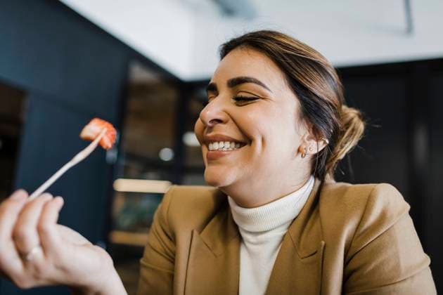 Happy businesswoman eating strawberry with fork at office model released, Symbolfoto property released, DCRF01782